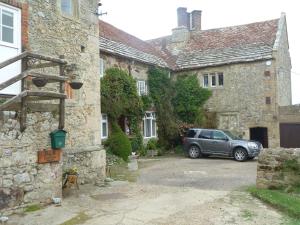 a car parked in front of a stone building at Westcourt Farm in Shorwell