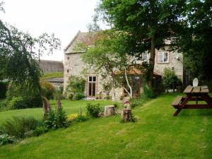 a stone house with a picnic table in the yard at Westcourt Farm in Shorwell