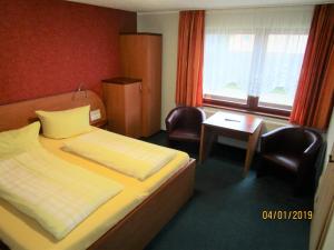a hotel room with a bed and a desk and window at Pension Willischza in Burg