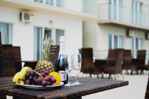 a table with a plate of fruit and a bottle of wine at VIP Hotel in Koblevo