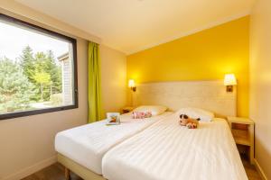 
a bedroom with a bed and a window at Center Parcs Les Trois Forêts in Hattigny
