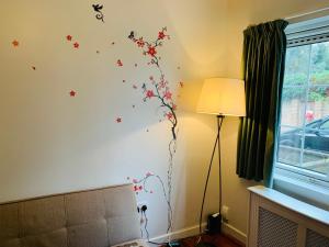 a room with a wall with flowers and butterflies on it at Tapestry Apartment in London