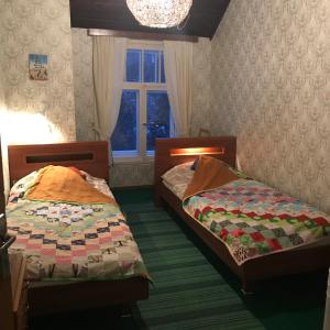 two twin beds in a room with a window at Annenhof Holiday House in Pudisoo