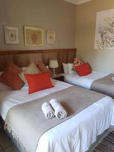 two beds sitting next to each other in a room at Honey Lodge in Klipdrift