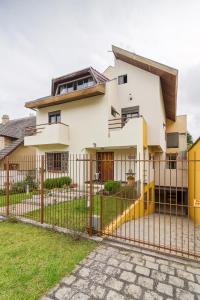 a house with a fence in front of it at Hospedagem Three Little Birds in Curitiba