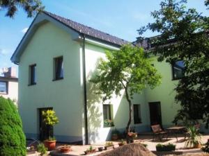 a white house with trees in front of it at Vila Evička in Sobotka