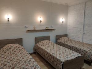 two beds in a room with lights on the wall at Yuzhny Briz Guest House in Yeysk