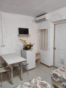 a room with a table and a tv on a wall at Yuzhny Briz Guest House in Yeysk