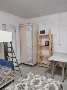 a room with a refrigerator and a table and chairs at Yuzhny Briz Guest House in Yeysk
