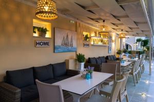 a restaurant with tables and chairs and a couch at Solaris Apartment Kassiopi in Kassiopi