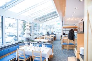 a restaurant with tables and chairs and windows at Hotel Toggenburgerhof in Kirchberg