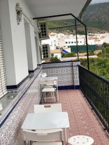 a balcony with tables and chairs on a building at Casa Antonio Algodonales in Algodonales