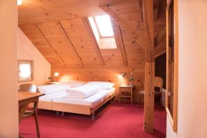 a bedroom with two beds in a wooden attic at Hotel Toggenburgerhof in Kirchberg