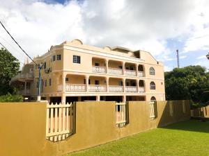 a building with a fence in front of it at Calliandras Apartment Complex in Kingstown +20 photos