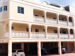 a building with balconies and a car parked in front at Calliandras Apartment Complex in Kingstown