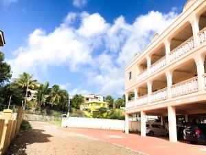 a building with cars parked in front of it at Calliandras Apartment Complex in Kingstown