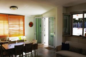 a dining room with a table and chairs and a room with at Delizioso appartamento isole Tremiti in San Domino