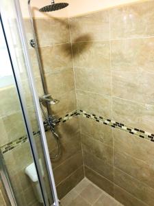 a bathroom with a shower with a glass door at Calliandras Apartment Complex in Kingstown