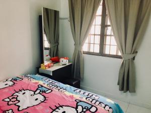 a bedroom with a bed with a cow comforter and a window at Bukit Katil Indah Homestay in Malacca