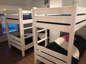 two white bunk beds sitting in a room at Landhaus zum Storchennest in Kloster Wulfshagen