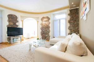 salon z białą kanapą i telewizorem w obiekcie The Rentals Collection | Camelot w mieście San Sebastián