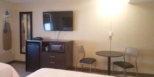 a hotel room with a table and a tv on the wall at The Dunes Rehoboth Beach in Dewey Beach