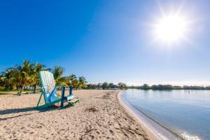 a beach chair sitting on a beach next to the water at KhalKob's Estate in Placencia Village
