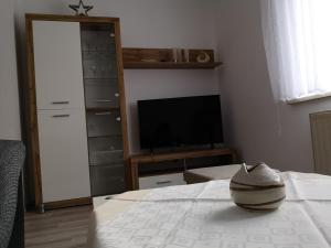 ein Wohnzimmer mit einem TV und einem Bett sowie ein Zimmer mit einem TV in der Unterkunft Ferienwohnung Elias in Merseburg