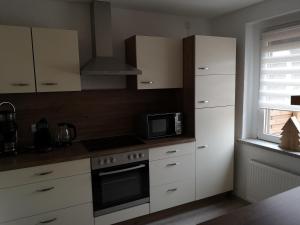 a kitchen with white cabinets and a microwave at Ferienwohnung Elias in Merseburg