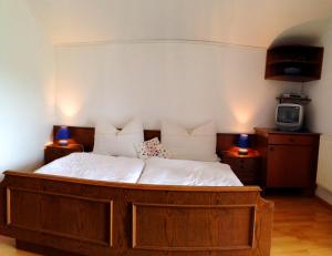 a bed in a room with two lamps and a tv at Apartments Urschitz in Drobollach am Faaker See