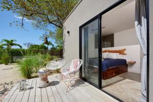 - une chambre avec un lit et des chaises sur une terrasse dans l'établissement Villa Ethir, à Tamarindo