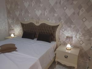 1 dormitorio con 1 cama blanca y 2 mesitas de noche en Luxury Apartment at Berges Lac2 en Túnez