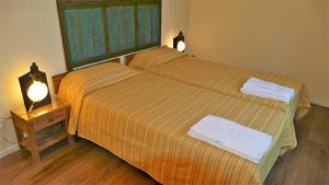 ボローニャにあるCasa Munayの小さな部屋のベッド2台 ベッド1台の上にランプ2つが備わります。