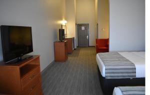 a hotel room with a bed and a flat screen tv at Country Inn & Suites by Radisson, Northwood, IA in Northwood