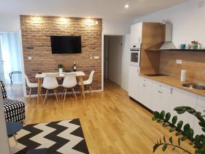 a kitchen with a table and chairs and a brick wall at HOME APARTMANI I SOBE in Osijek