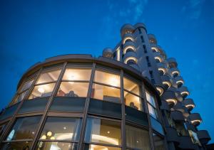 a building with glass windows in front of a building at Hotel Meeting in Riccione