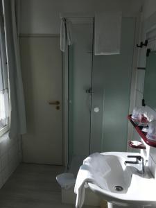 ein weißes Bad mit einer Dusche und einem Waschbecken in der Unterkunft Parkhotel Villa des Effats Vielsalm in Vielsalm