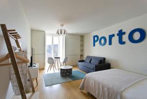 ポルトにあるVitoria Studio Residence - Downtownのベッドルーム(ベッド1台、青いソファ付)