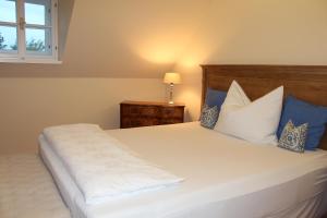 1 dormitorio con 1 cama blanca grande con almohadas azules en Burgunderhof - Steiermark, en Sankt Anna am Aigen