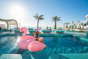 
a woman in a pink swimsuit and a man in a pink swimsuit at Dorado Ibiza - Adults Only in Playa d'en Bossa
