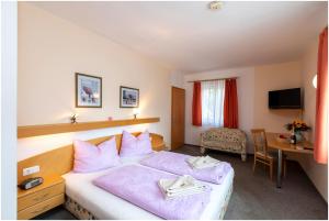 una camera d'albergo con un letto e una scrivania di Gasthof Weingrill a Friesach