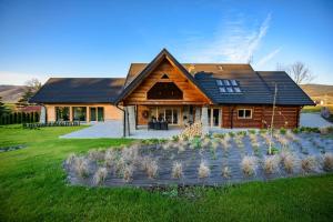 una casa de madera con un paisaje delante de ella en Łabowska Chata - Basen, Sauna, Grota solna en Łabowa