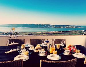 a table with plates and wine glasses and a view of the ocean at View Lagoon in Foz do Arelho