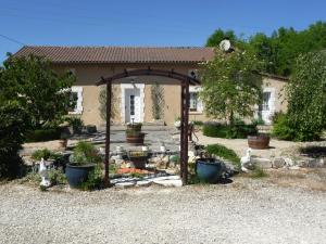 einen Garten mit einer Laube und Pflanzen vor einem Haus in der Unterkunft Les Tuileries in Ponteyraud