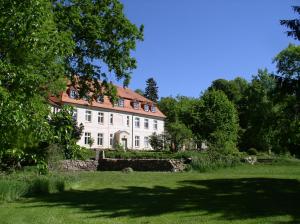 uma grande casa branca com um telhado vermelho em Gartenzimmer im Schloss Neuhausen em Neuhausen