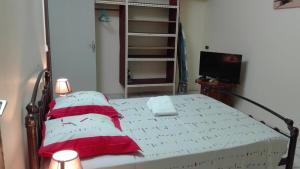a bedroom with a bed with red and white sheets at Cayenne - 2313 Route de la Madeleine in Cayenne
