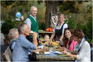 Eine Gruppe von Menschen, die an einem Tisch sitzen und Essen essen. in der Unterkunft Gasthof Weingrill in Friesach