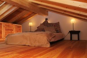 a bedroom with a bed with wooden floors and wooden ceilings at Baite La Pedruscia in Val Masino
