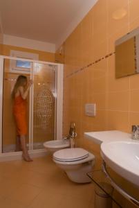 a woman standing in a shower in a bathroom at Villa Boer in Bibione