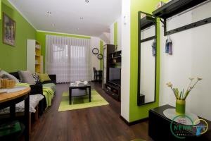 a living room with green walls and a couch at Guest House Nena Rastoke in Slunj